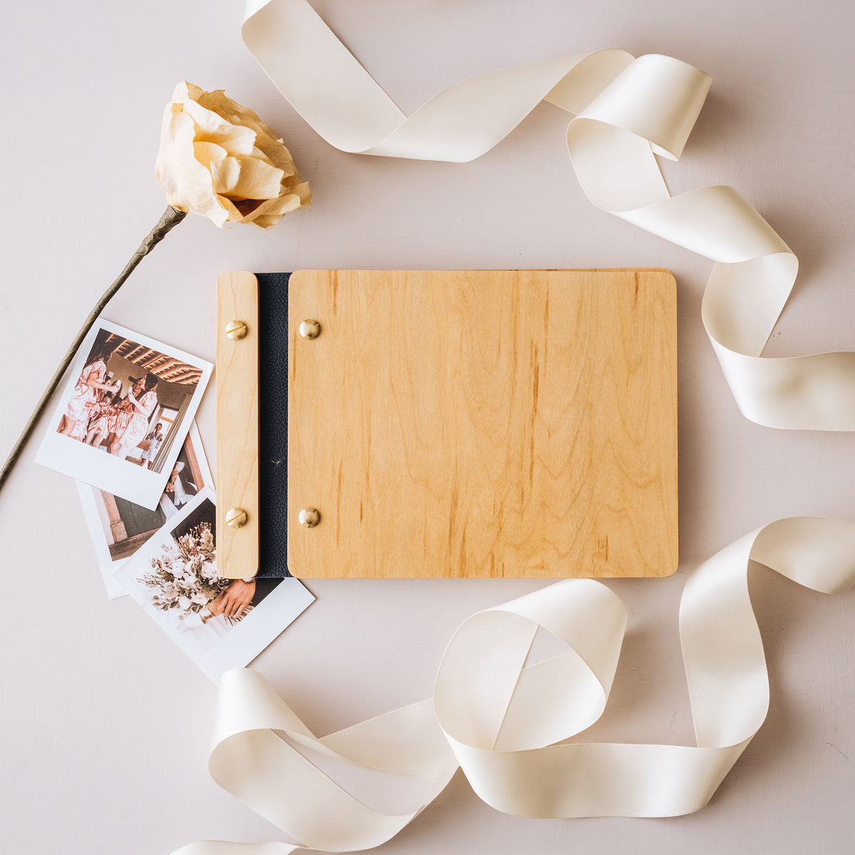 Wooden wedding guest book with a navy leather spine, ribbon and instant photos