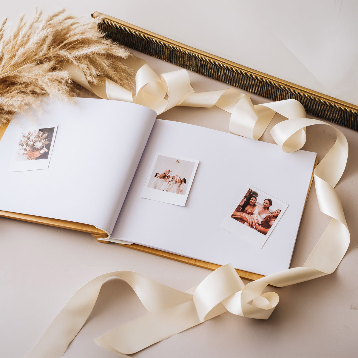 Open guest book with white pages, pampas grass and ribbon