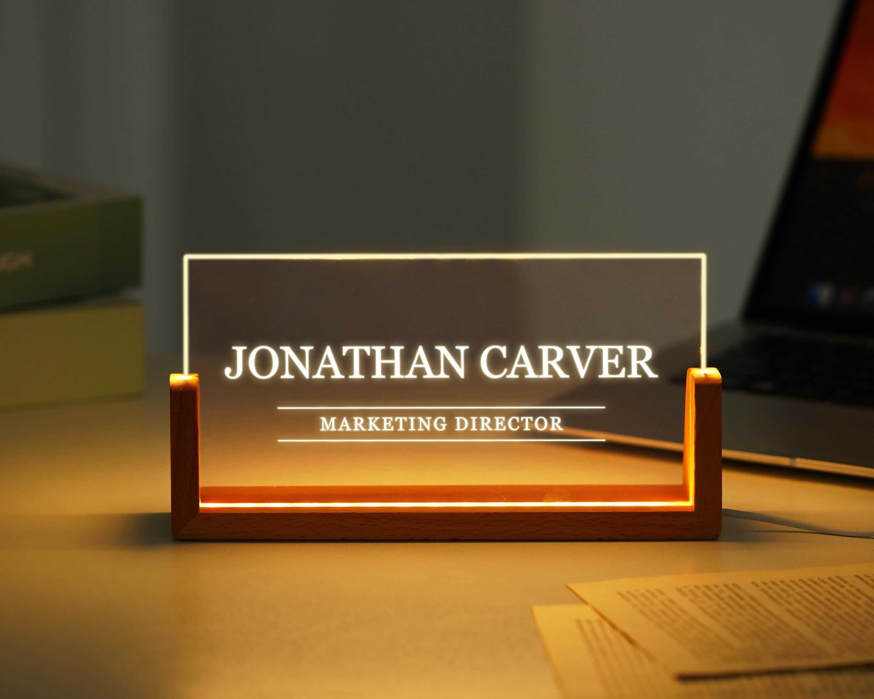 a desk with a laptop and a business card holder