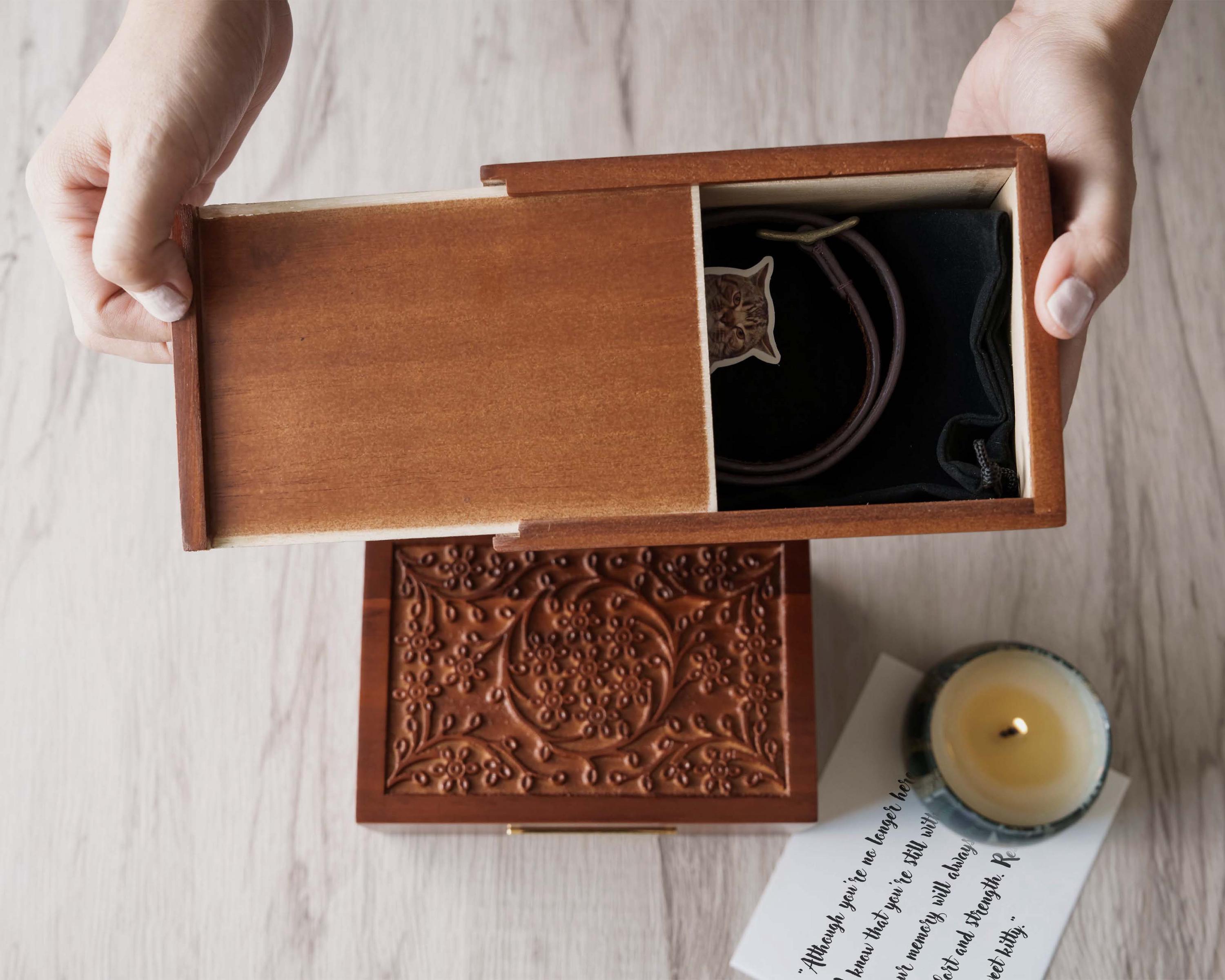 a person holding a wooden box with a candle in it