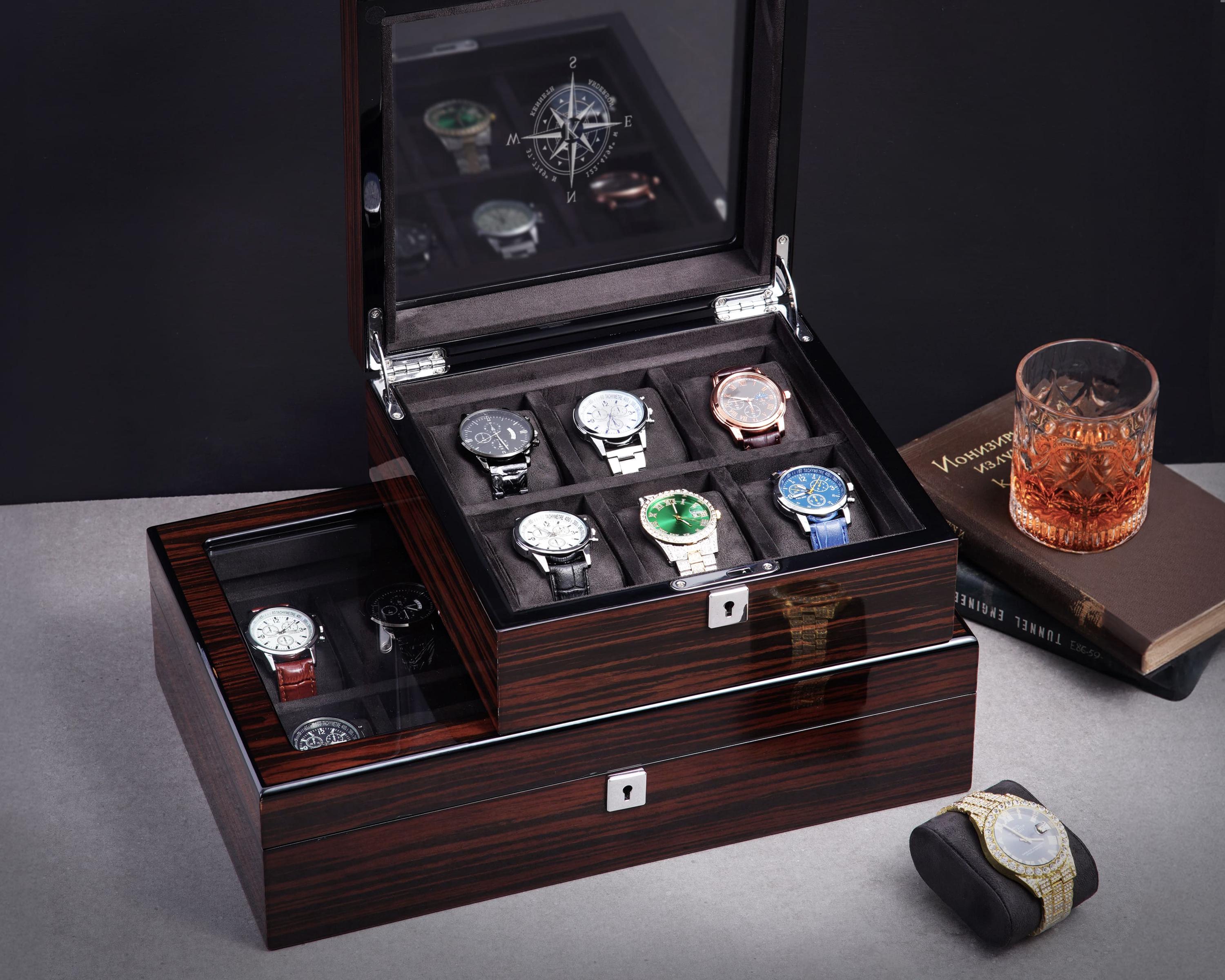a wooden watch box with a glass of whiskey and a book