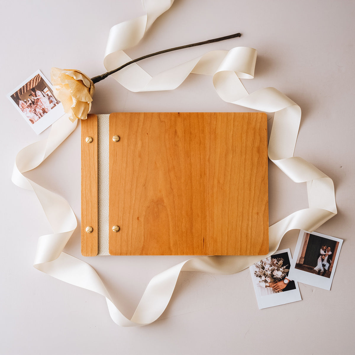 Cherry wood guest book with a white leather spine, ribbon and instant photos