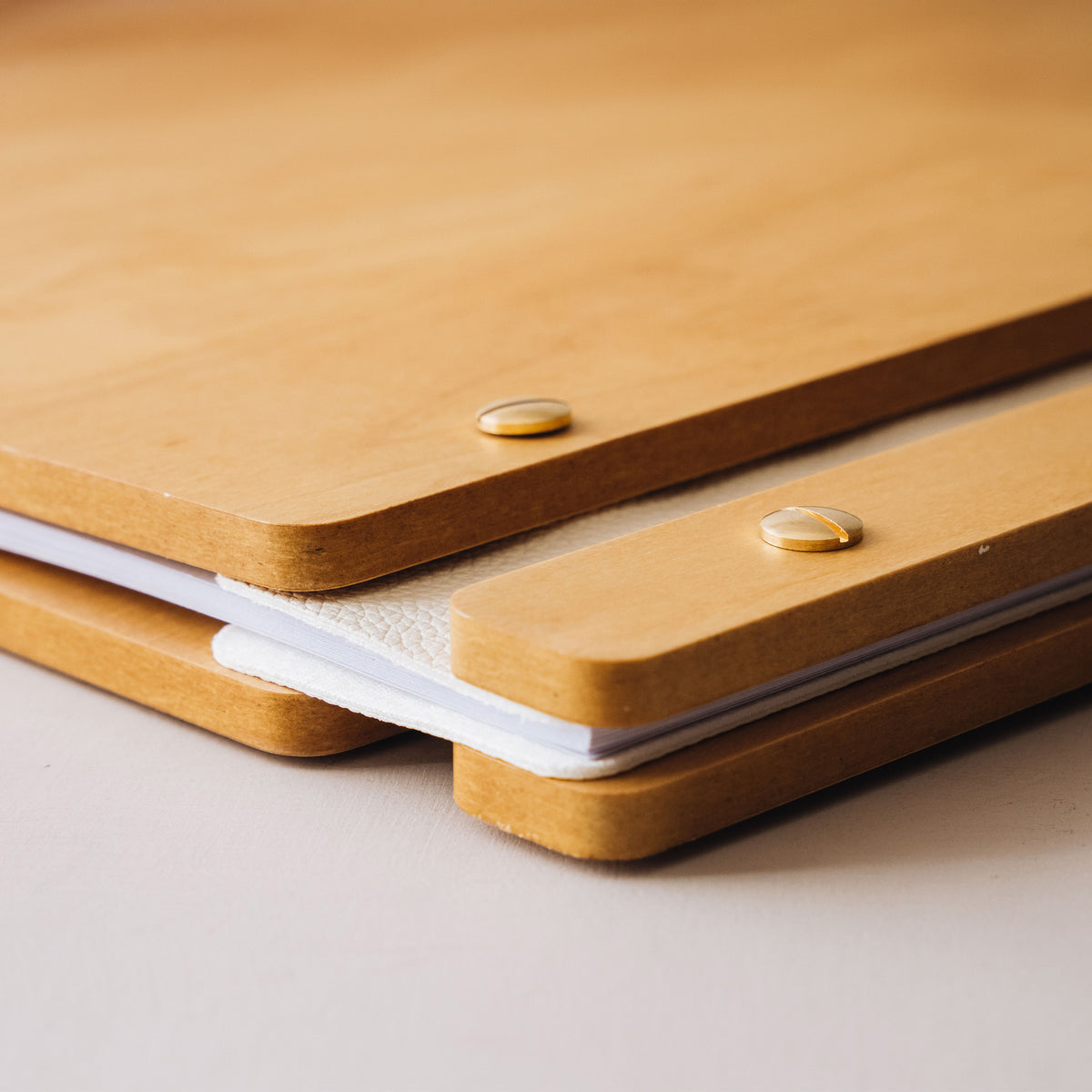Edge of the wooden guest book cover with screw post