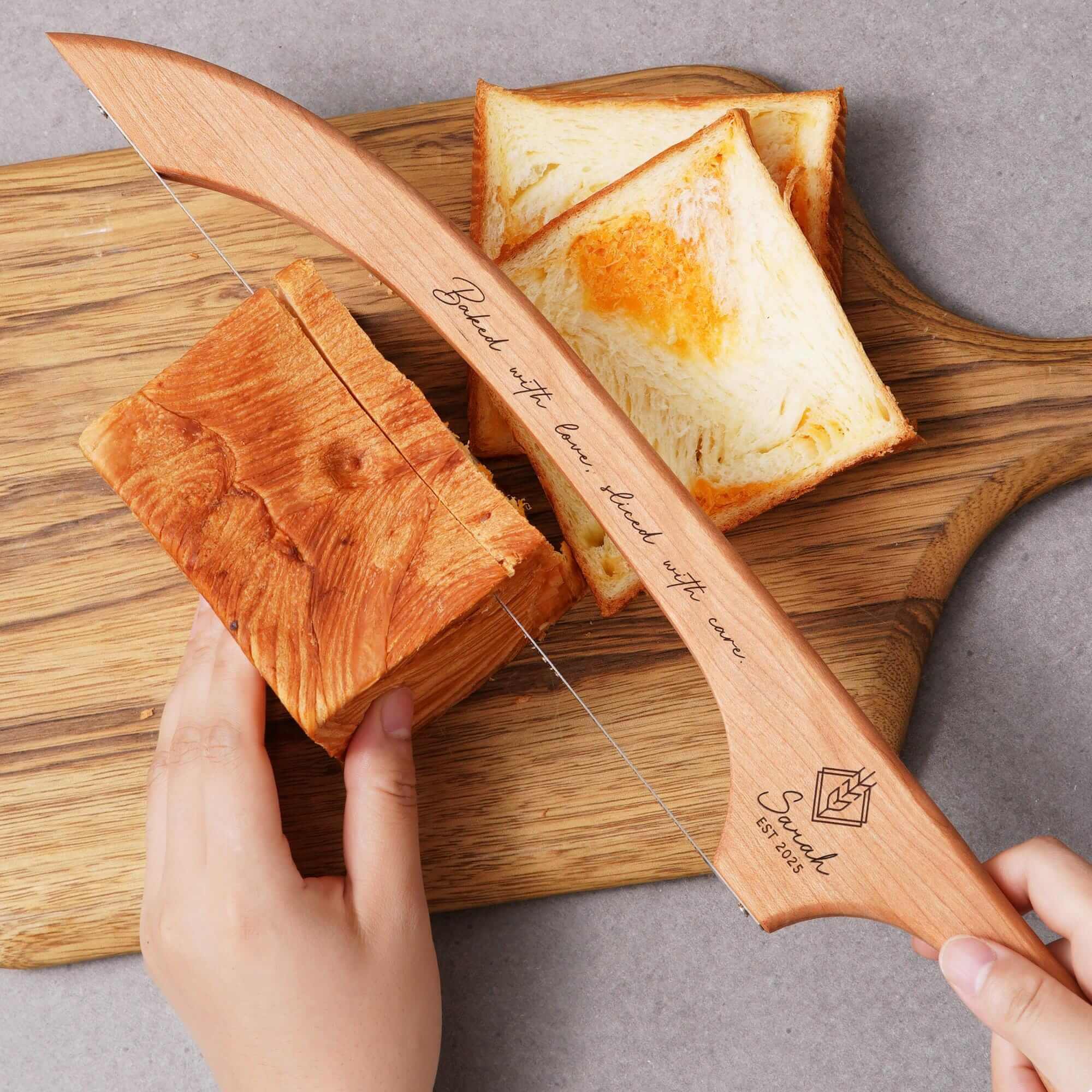 a person cutting bread with a knife on a cutting board