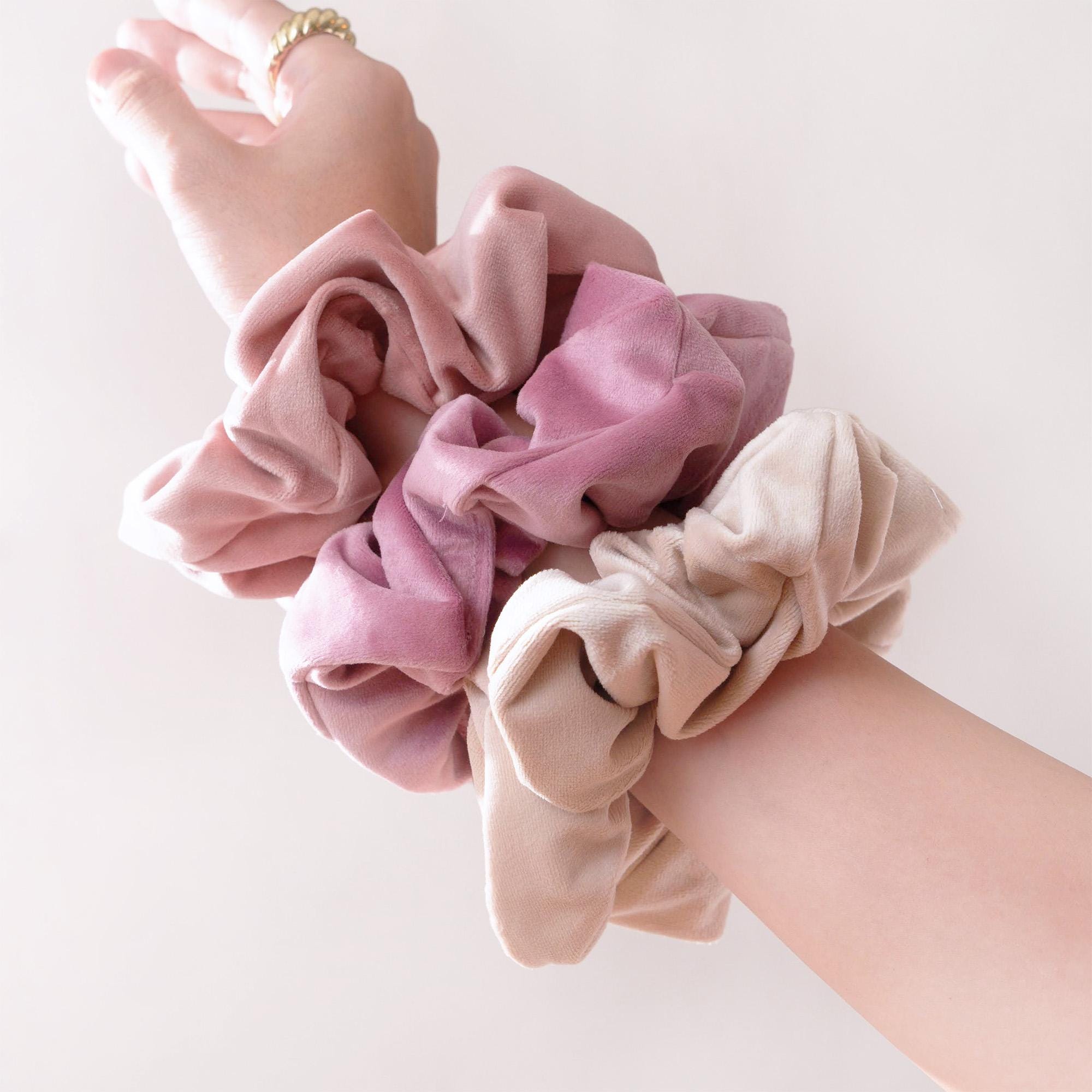 a woman&#39;s arm with a pink scrunffle on it