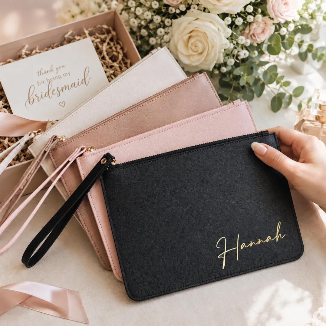 Personalized bridesmaid clutch bag in black with gold script name, shown with blush and white clutches