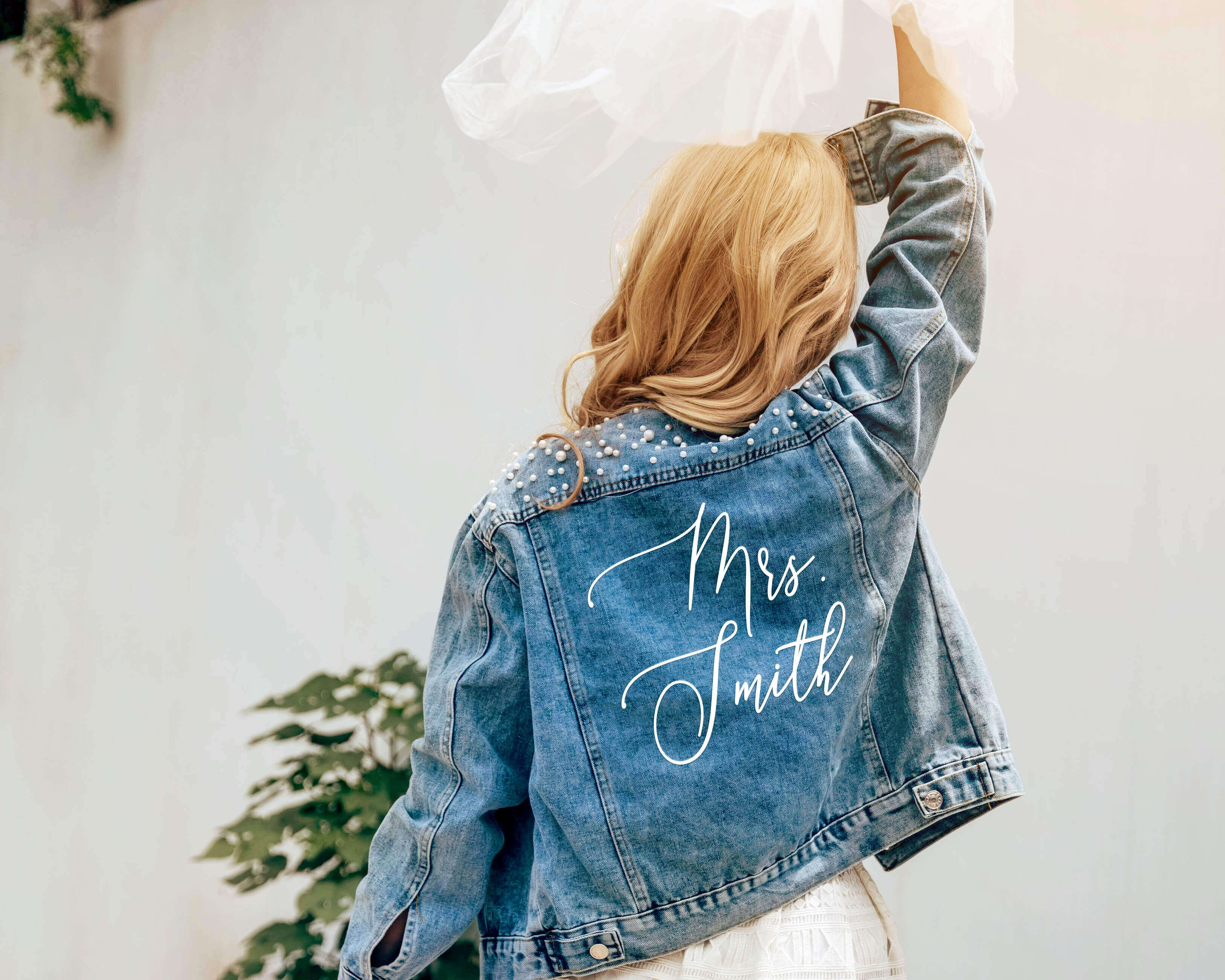 A beautiful bride wear a custom bride jean jacket with custom text on her wedding day.